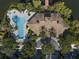 Aerial view of a community pool, hot tub, and clubhouse with a parking area and tropical landscaping at 1795 Piedmont Pl, Lake Mary, FL 32746