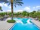 Community pool and sundeck overlooking the lake featuring lounge chairs, palm trees, and lush landscaping at 1795 Piedmont Pl, Lake Mary, FL 32746