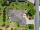 Aerial shot of a home showcasing lush landscaping, a well-manicured lawn, and a circular driveway at 1842 Lake Ridge Dr, The Villages, FL 32162