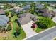 Aerial view of a home showcasing a manicured lawn, beautiful landscaping, and a circular driveway at 1842 Lake Ridge Dr, The Villages, FL 32162