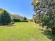 Spacious backyard with manicured lawn and mature trees offering serene outdoor space at 1842 Lake Ridge Dr, The Villages, FL 32162