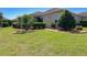 Landscaped backyard featuring lush green grass, trimmed shrubs, and mature trees offering shade and privacy at 1842 Lake Ridge Dr, The Villages, FL 32162