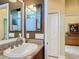 Well-lit bathroom featuring single sink, granite countertop, and doorway to bedroom at 1842 Lake Ridge Dr, The Villages, FL 32162