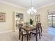 Cozy dining room with a wooden table, chandelier, and a view of the lanai at 1842 Lake Ridge Dr, The Villages, FL 32162