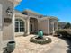 Charming front exterior with a beautiful water feature, manicured landscaping, and an inviting entryway at 1842 Lake Ridge Dr, The Villages, FL 32162