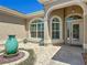 Attractive front exterior featuring a water feature, decorative planters, arched windows, and a stylish front door at 1842 Lake Ridge Dr, The Villages, FL 32162