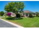 Attractive home with lush green lawn, mature trees, and beautiful landscaping enhancing curb appeal at 1842 Lake Ridge Dr, The Villages, FL 32162