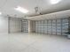 Spacious three-car garage with epoxy floor, featuring two garage doors and an abundance of space at 1842 Lake Ridge Dr, The Villages, FL 32162