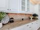 Close-up of kitchen counter featuring granite countertops, white cabinets, and decorative backsplash at 1842 Lake Ridge Dr, The Villages, FL 32162