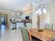 Bright open kitchen with white cabinets, stainless steel appliances, and views of the dining area at 1842 Lake Ridge Dr, The Villages, FL 32162