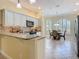 Bright open kitchen with white cabinets, stainless steel appliances, and a dining area with arched windows at 1842 Lake Ridge Dr, The Villages, FL 32162