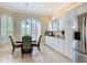 Sunlit kitchen with white cabinets, stainless steel appliances, and a dining area with arched windows at 1842 Lake Ridge Dr, The Villages, FL 32162