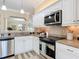 Bright open kitchen featuring granite countertops, stainless steel appliances and white cabinets at 1842 Lake Ridge Dr, The Villages, FL 32162