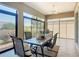 Tiled lanai featuring an outdoor dining table set, ceiling fan, and views of the green outdoor foliage at 1842 Lake Ridge Dr, The Villages, FL 32162