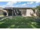 Exterior of the house backyard featuring a grill on the lawn with a screen door at 1893 Banning Beach Rd, Tavares, FL 32778