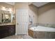 Beautiful bathroom featuring a corner tub, spacious vanity, and natural lighting, creating a relaxing retreat at 1893 Banning Beach Rd, Tavares, FL 32778