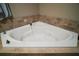 Large soaking tub with jacuzzi jets, and stylish tile surround, perfect for unwinding after a long day at 1893 Banning Beach Rd, Tavares, FL 32778