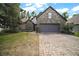 Charming stone-accented home featuring a paver driveway, manicured lawn, and attached two-car garage at 1893 Banning Beach Rd, Tavares, FL 32778