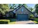 Charming exterior view of a stone-accented home with a paved driveway and well-manicured landscaping at 1893 Banning Beach Rd, Tavares, FL 32778