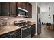 Stylish kitchen boasts stainless steel appliances, dark wood cabinets, and granite countertops at 1893 Banning Beach Rd, Tavares, FL 32778