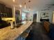 Open kitchen with granite counters, dark cabinets, stainless appliances and stools at the island at 1893 Banning Beach Rd, Tavares, FL 32778