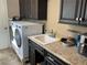 Well-equipped laundry area features modern washer/dryer, sleek countertops, and cabinets for organized convenience at 1893 Banning Beach Rd, Tavares, FL 32778