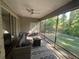 Relaxing screened-in patio with outdoor seating, a ceiling fan, and a beautiful backyard view at 1893 Banning Beach Rd, Tavares, FL 32778