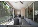 Cozy screened porch with comfortable seating, fire table, and views of the lush backyard at 1893 Banning Beach Rd, Tavares, FL 32778