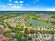 Aerial view displays a single-story home located in a neighborhood with a community lake, golf course and beautiful green space at 2102 Estevez Dr, Lady Lake, FL 32159