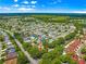 Scenic aerial view of a neighborhood with lush greenery and well-maintained homes under a bright blue sky at 2102 Estevez Dr, Lady Lake, FL 32159