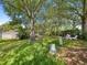 A spacious backyard with a lush lawn, mature trees, and patio furniture provides a relaxing outdoor space at 2102 Estevez Dr, Lady Lake, FL 32159