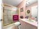 Cozy bathroom with shower, toilet and a sink with pink details at 2102 Estevez Dr, Lady Lake, FL 32159