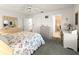 Well-lit bedroom with coordinated furniture, floral bedding, and views to the en-suite bathroom at 2102 Estevez Dr, Lady Lake, FL 32159