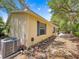 The side of this home has an exterior air conditioning unit, and tasteful landscaping of flowers and stones at 2102 Estevez Dr, Lady Lake, FL 32159