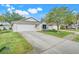 Charming single-story home featuring a well-manicured lawn and two car garage at 2136 Fish Eagle St, Clermont, FL 34714