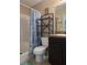 Bathroom with tub and shower features a single sink vanity, storage shelving, and seashell themed decor at 222 Locust Ln, Ocala, FL 34471