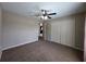 Spacious bedroom featuring neutral paint, carpeted floors, and a ceiling fan, with a view into the hallway at 222 Locust Ln, Ocala, FL 34471