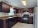Traditional kitchen featuring dark cabinets, tile flooring and black appliances at 222 Locust Ln, Ocala, FL 34471