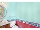 Powder room featuring a circular mirror, floral wallpaper border, and toilet at 2400 N Griffin Dr, Leesburg, FL 34748