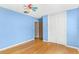 This cozy bedroom features blue walls, hardwood floors, a ceiling fan and a closet for storage and comfort at 2400 N Griffin Dr, Leesburg, FL 34748
