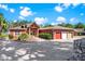 Charming one-story home featuring a circular driveway, three-car garage, and picturesque landscaping at 2400 N Griffin Dr, Leesburg, FL 34748