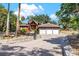 Spacious red home with a three-car garage and a beautiful brick-paved circular driveway at 2400 N Griffin Dr, Leesburg, FL 34748
