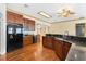 Spacious kitchen with wood floors, granite countertops, dark wood cabinetry and stainless steel refrigerator at 2400 N Griffin Dr, Leesburg, FL 34748