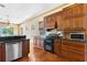 Bright kitchen features wood cabinets, granite countertops, stainless steel appliances and wood flooring at 2400 N Griffin Dr, Leesburg, FL 34748