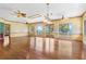 Open living room with hardwood floors, ceiling fans, a tray ceiling and a water view at 2400 N Griffin Dr, Leesburg, FL 34748
