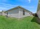 Exterior view of the home's backyard with green grass and partial view of outdoor patio at 2450 Kingstree Pl, The Villages, FL 32162