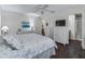 Bright bedroom featuring wicker furniture, ceiling fan, and access to the en-suite bathroom at 2450 Kingstree Pl, The Villages, FL 32162