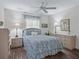 Comfortable bedroom featuring blue floral bedding, wood-look floors, and ample natural light at 2450 Kingstree Pl, The Villages, FL 32162