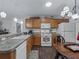 Efficient kitchen with oak cabinets, modern appliances, and an adjacent dining area at 2450 Kingstree Pl, The Villages, FL 32162