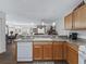 Open kitchen with light oak cabinetry, and a view of the adjacent dining and living areas at 2450 Kingstree Pl, The Villages, FL 32162